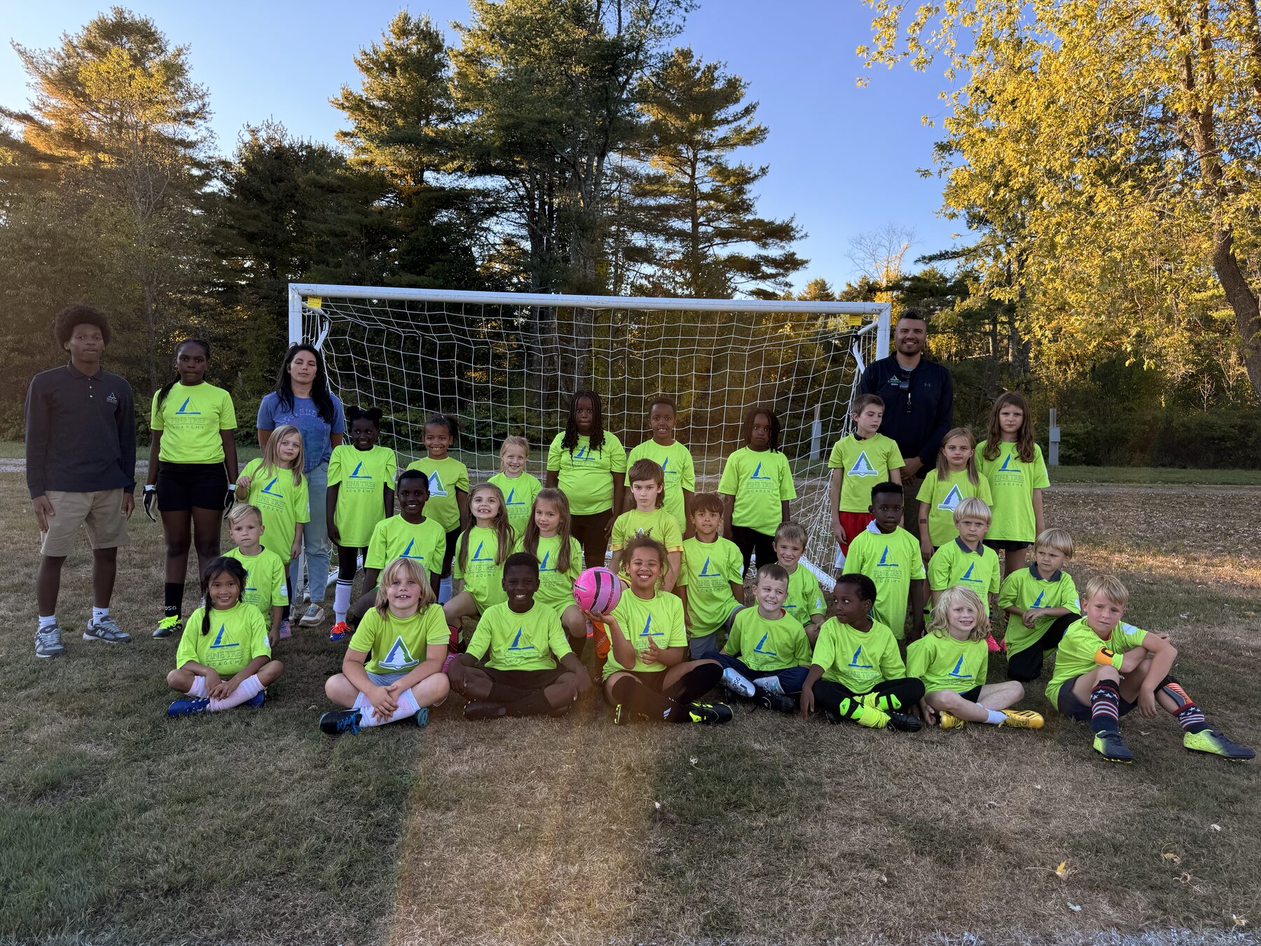 Pine Tree Academy Littles soccer players gathered in front of a goal on the campus field